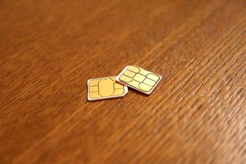 Two SIM cards for mobile cellular phones and roaming services on a wooden s.. Stock Photos
