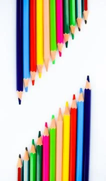 Two similar looking row of different colored pencil crayons arranged facing e Stock Photos