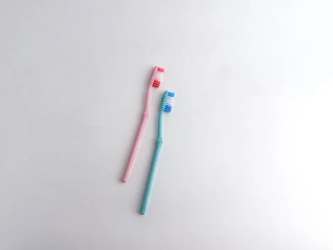 Two simple pink and blue manual toothbrushes isolated on a clean white back.. Stock Photos