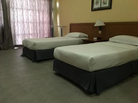 Two single beds in the room are in good condition. Stock Photos