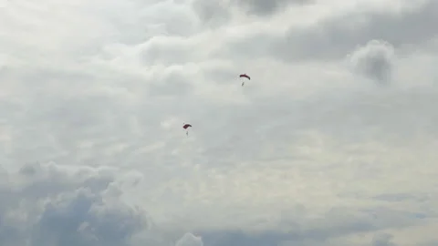 Two single Skydivers with open Parachutes slowely glide down to earth. The Stockbeeldmateriaal 162565266
