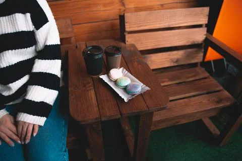 Two single use disposable cups with coffee and macarons on the wooden table Stock Photos
