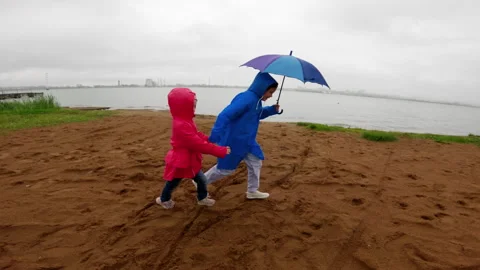 Two sister are running on a sandy beach in slow motion. They are wearing Stock Footage 290458581