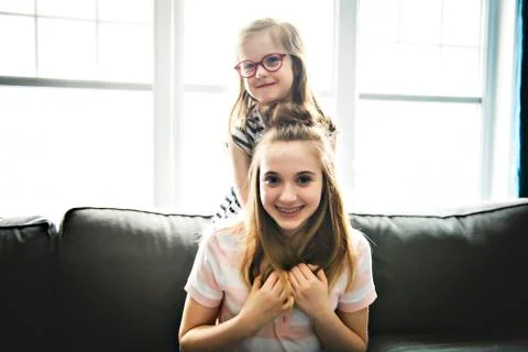 Two sister having fun on the sofa 写真素材