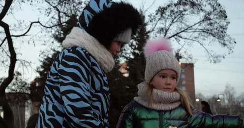 Two sisters 9 and 6 years with mother walking in winter twilight. Family stroll Stock Footage 319791274