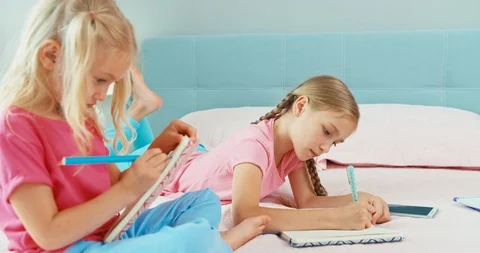Two sisters are on the bed and something drawing Stock Footage 95647781