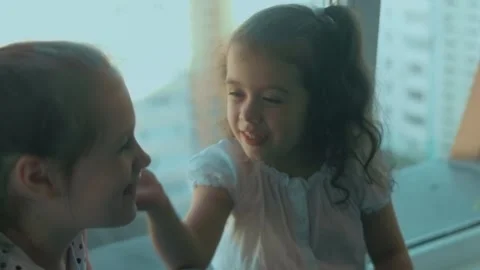 Two sisters are having fun, talking and sharing stories, sitting on the Stock Footage 251732019