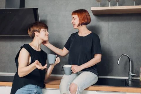 Two sisters are talking in the kitchen while drinking tea Foto stock