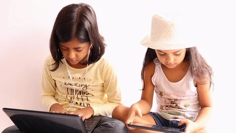 Two sisters are using their notebooks and sharing something funny Stock Footage
