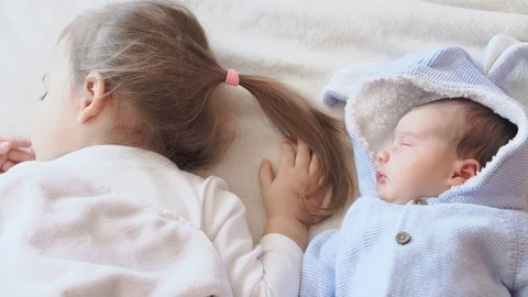 Two sisters , babies on the bed sleeping. Concept: sweet dreams Stock Footage 128409573