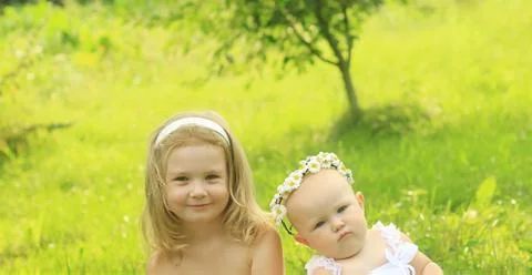 Two sisters on the background of a summer meadow Stock Photos