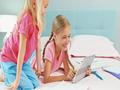 Two sisters on bed using tablet pc Stock Footage 84877367
