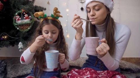 Two sisters catch a spoon of cocoa marshmallows Vidéo 120706341