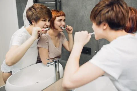 Two sisters cleaning their teeth in the morning Stock Photos