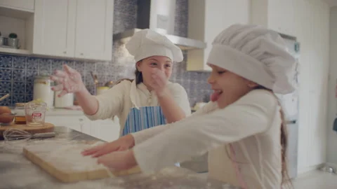 Two sisters cooking dough in the kitchen Stock Footage 279730044