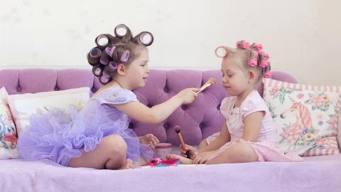 Two sisters in curlers make each other a make-up. 4k Stock Footage 89970593