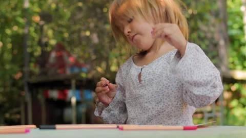 Two sisters drawing with fineliners in notebooks at a small table in a summ.. Stock Footage 304149105