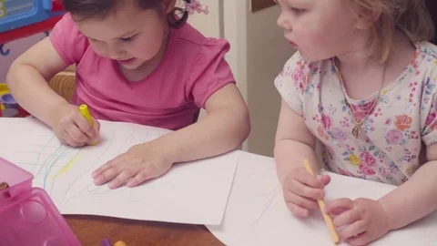 Two sisters drawing at a table Stock Footage 76955048