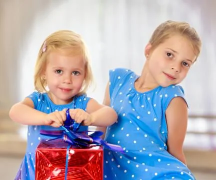 Two sisters with a gift Stock Photos