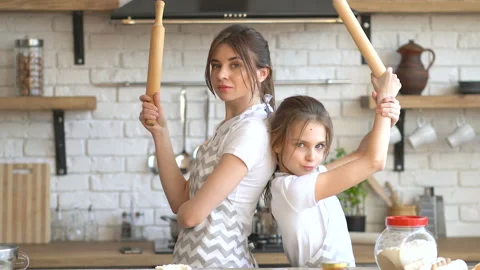 Two sisters having fun and posing at the kitchen. Steadycam shot. Stock Footage 106546392