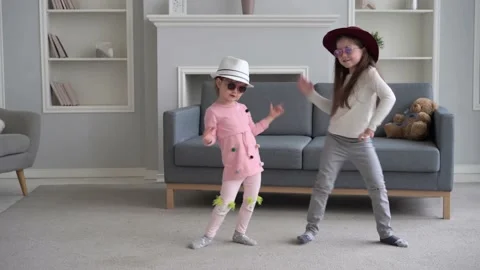Two sisters jumping having fun in living room, active cheerful girls dancing Stock Footage 132889588