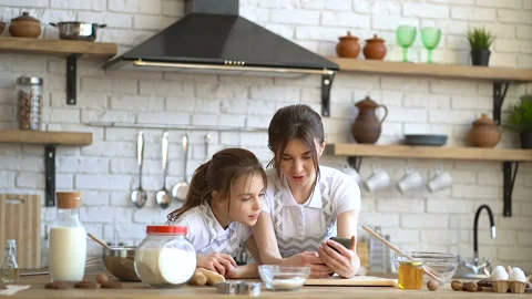 Two sisters looking recipe at the smartphone and cheking ingredients before. Stock Footage 106411799