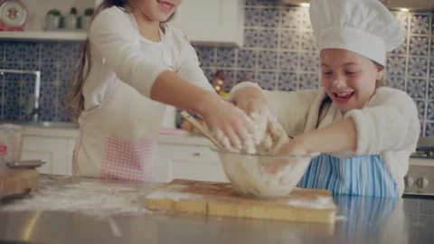 Two sisters making dough in the kitchen Stock Footage 279742802