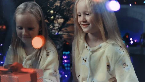 Two sisters open a new year gift Stock Footage 94702309