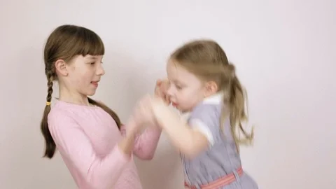 Two sisters play and have fun, children's emotional portraits on white Stock Footage 106443221