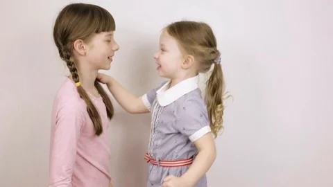 Two sisters play and have fun, children's emotional portraits on white Stock Footage 106443531