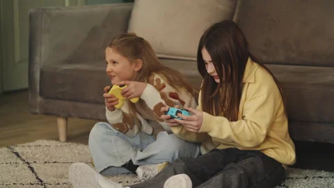 Two sisters play video game with gamepads at home, upset after a tough loss Stock Footage 343423831