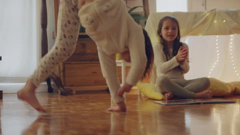 Two sisters playing and one if doing a handstand Stock Footage 279743574
