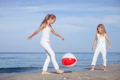 Two sisters playing on the beach at the day time. 写真素材