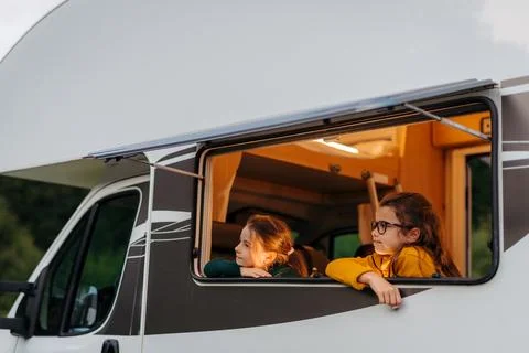 Two sisters playing inside camper during family summer vacation. Stock Photos