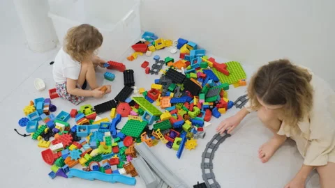 Two sisters playing with large colorful block set Видео 335425490