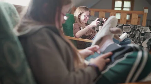 Two Sisters Playing Mobile Game on Smartphones Together at Home 動画素材 337795830