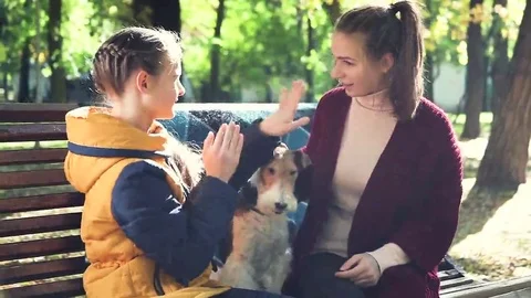 Two sisters playing in the park sitting on the bench Stock Footage 69168455