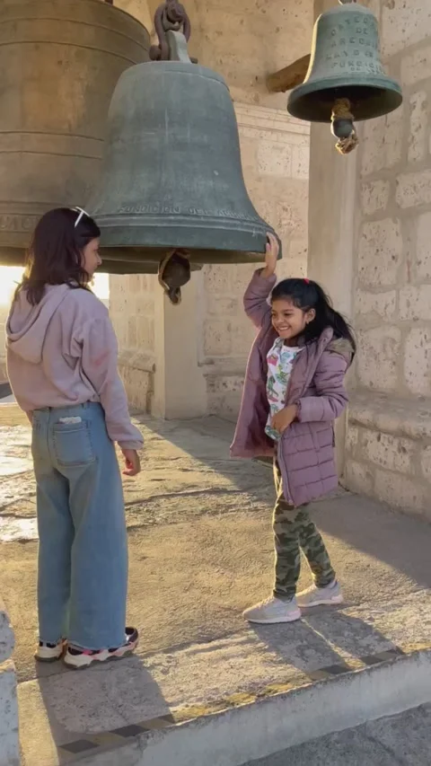 Two sisters posing in front of a bell tower. Arequipa Stock Footage 280094731