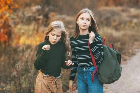 The two sisters return from school and talk as they drive through an open-air Stock Photos