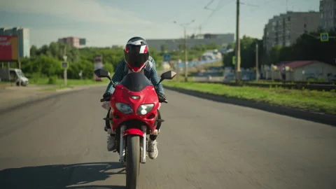 Two Sisters Riding a Red Power Bike Through an Urban Road with Blurred Stock Footage 285622191