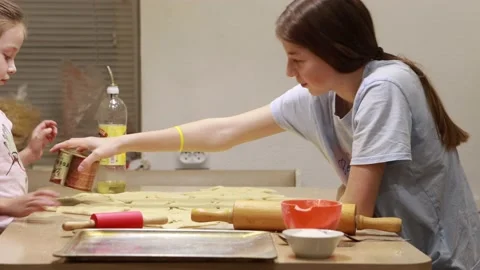 Two sisters roll out dough for cooking and baking homemade buns Stock Footage 167023851