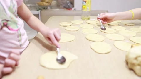 Two sisters roll out dough for cooking and baking homemade buns Stock Footage 167024393
