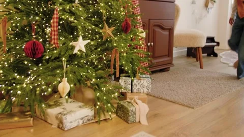Two sisters running after presents lying under the Christmas tree at Christmas. Stock Footage 293450012