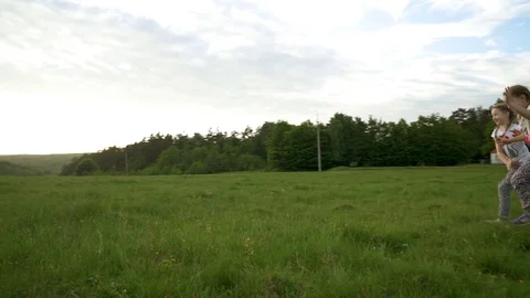 Two sisters running and having fun in meadow Video stock 98066134