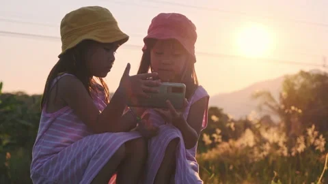 Two sisters sit on the tracks and take selfies together at sunset. Stock Footage 170605361