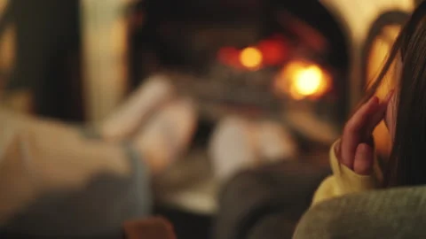 Two sisters spend time together by a warm fireplace, cozy holiday atmosphere Stock Footage 343423776