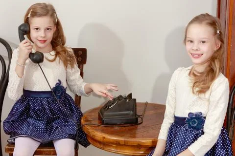 Two sisters talking on old phone Stock Photos