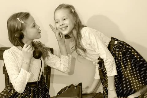 Two sisters talking on old phone Stock Photos