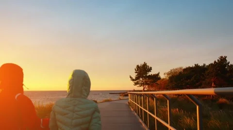 Two sisters walking along shore of Baltic Sea Stock Footage 65768496