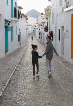 Two Sisters walking hand in hand through the town of Altea. Stock Photos